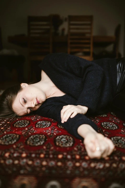 a woman laying on top of a rug on the floor, a picture, inspired by Elsa Bleda, trending on pexels, renaissance, concerned, androgynous person, on a velvet tablecloth, attractive photo