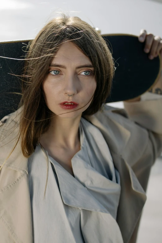 a woman holding a skateboard over her head, inspired by Gyula Basch, trending on unsplash, renaissance, wearing a long beige trench coat, closeup headshot portrait, portrait. 8 k high definition, porcelain skin ”