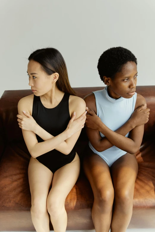 a man and a woman sitting on a couch, by Nina Hamnett, pexels, renaissance, muted colored bodysuit, her friend, asian women, arms crossed