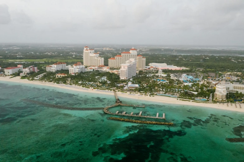 a large body of water next to a beach, by Josh Bayer, pexels contest winner, bahamas, aerial view of a city, overcast weather, resort