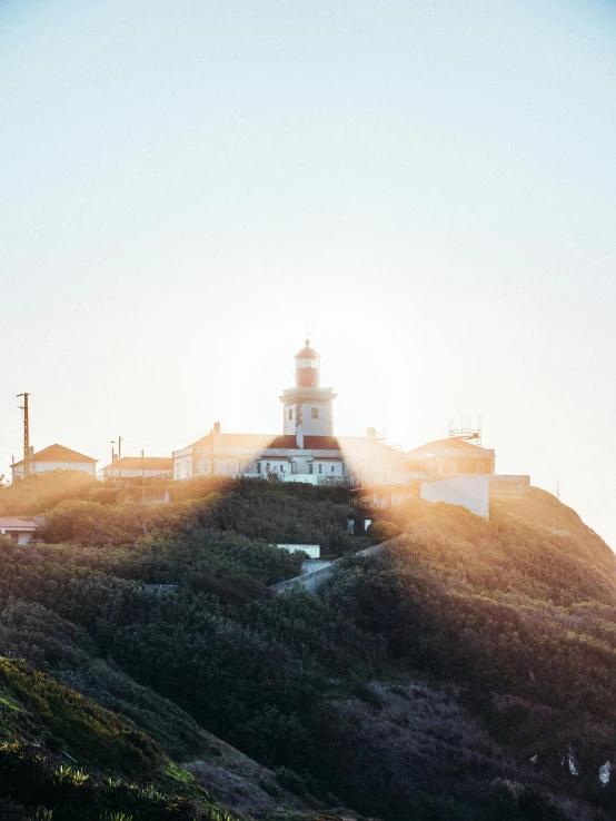 a lighthouse sitting on top of a lush green hillside, by Kristian Zahrtmann, pexels contest winner, happening, light breaks through the roofs, sunfaded, thumbnail, front lit