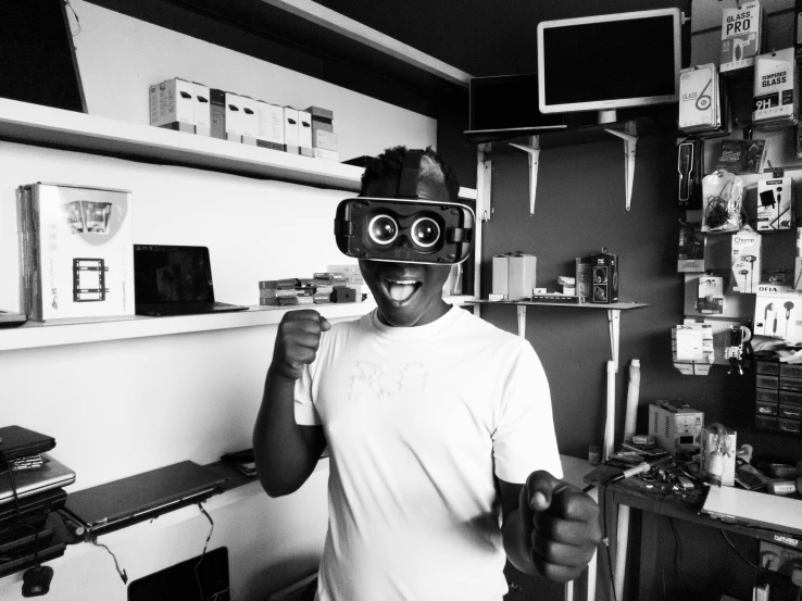 a black and white photo of a man holding a camera, afrofuturism, vr glasses, happy robot, in the office, frontal pose