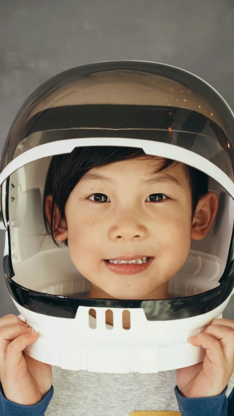 a close up of a child wearing a helmet, by Alison Geissler, space exploration, young cute wan asian face, thumbnail, ben lo