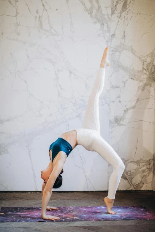 a woman doing a handstand pose on a yoga mat, a marble sculpture, by Arabella Rankin, pexels contest winner, arabesque, white leggings, wall, arched back, full body picture