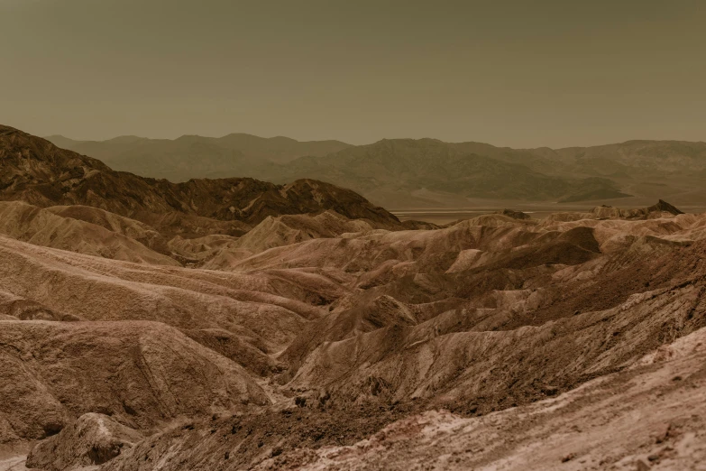 a view of the desert from the top of a hill, a colorized photo, unsplash contest winner, tonalism, geological strata, promo image, tatooine, mountainous background