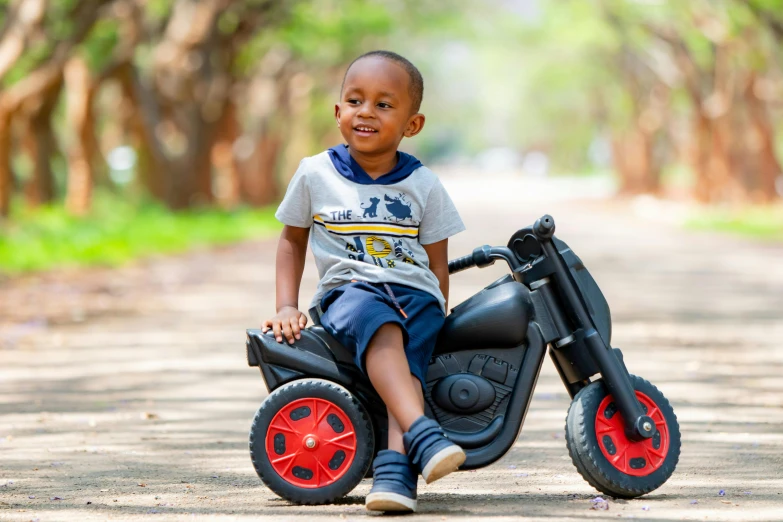 a young boy sitting on a toy motorcycle, by Samuel Scott, pexels contest winner, mongezi ncaphayi, thumbnail, modelling, profile image