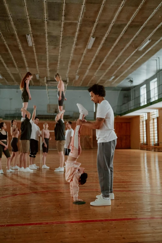 a group of people standing on top of a basketball court, arabesque, with a kid, game ready, tall ceiling, movie still frame