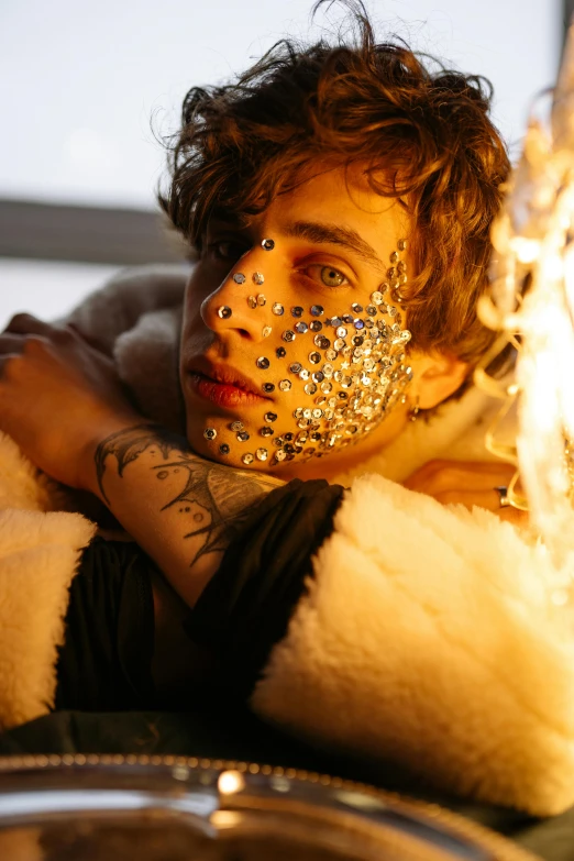 a close up of a person with tattoos on their face, an album cover, inspired by Hedi Xandt, timothee chalamet, with lots of glittering light, bathed in the the glow of a fire, slide show