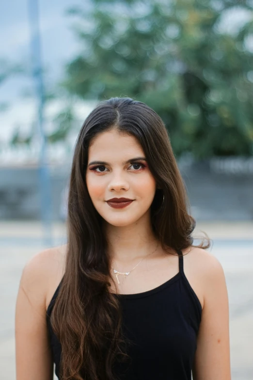 a woman in a black dress posing for a picture, inspired by Emma Ríos, dark brown hair and tan skin, cynthwave, high quality image, 18 years old