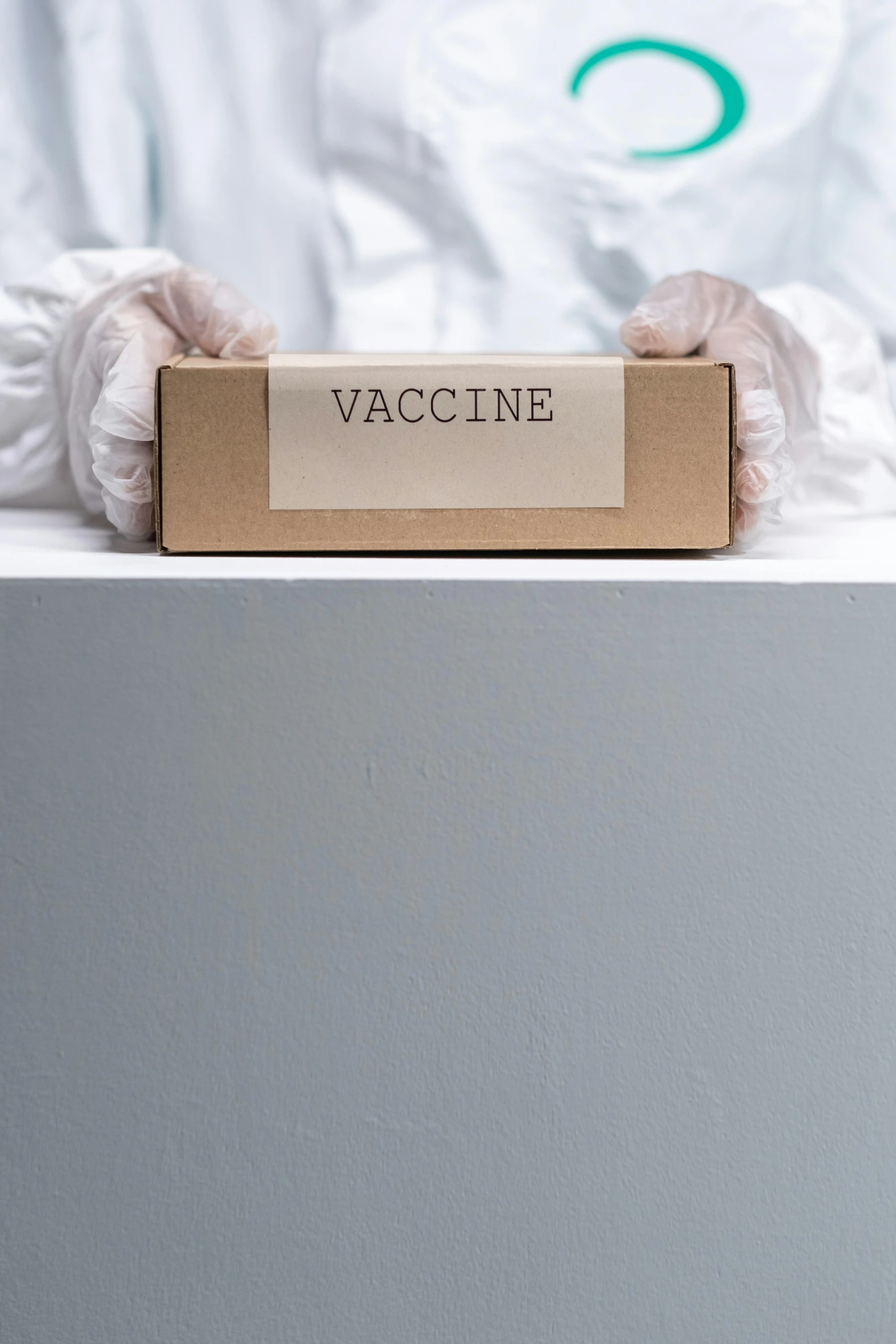 a person holding a box with the word vaccine on it, an album cover, by Rachel Reckitt, shutterstock, happening, labcoat, alessio albi, grey, cardboard