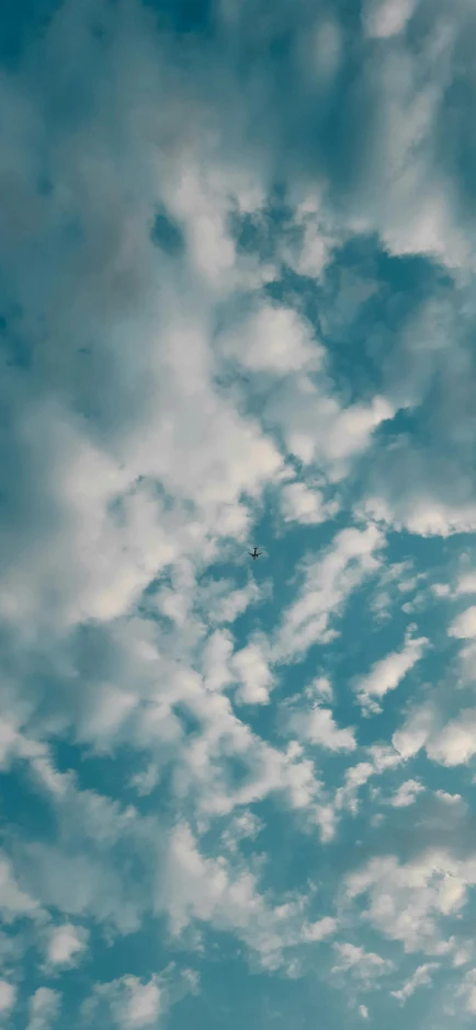 a man riding a snowboard on top of a snow covered slope, an album cover, inspired by Elsa Bleda, pexels contest winner, minimalism, tall fluffy clouds, drone photograpghy, cloud in the shape of a dragon, view from below