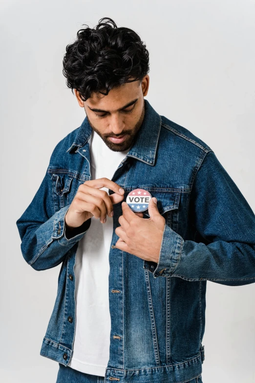 a man in a white t - shirt and a denim jacket, a cartoon, trending on unsplash, muslim, ad campaign, buttons, wearing presidential band