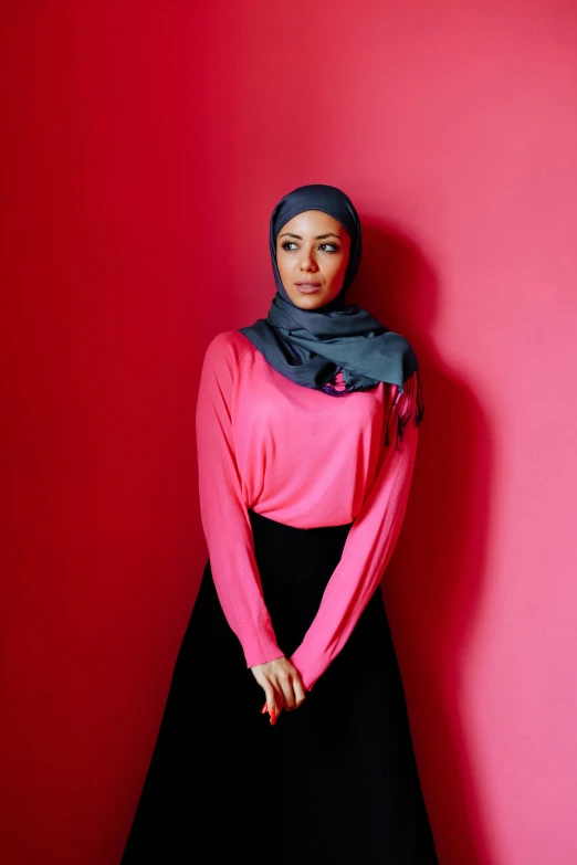 a woman in a pink shirt and black skirt, inspired by Maryam Hashemi, featured on instagram, hurufiyya, in red background, dark grey, riyahd cassiem, ap press photo