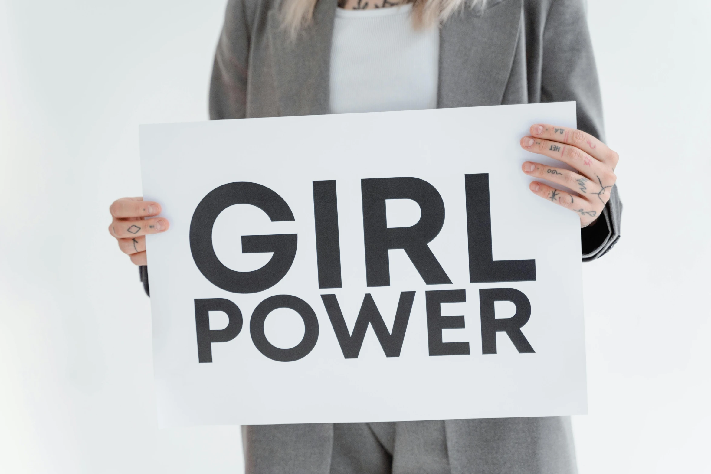 a woman holding a sign that says girl power, a poster, inspired by Harriet Powers, trending on pexels, grey, circuit, product shot, amanda lilleston