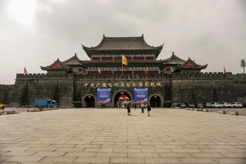 a group of people standing in front of a building, an album cover, inspired by Zhang Sengyao, pexels contest winner, fortress gateway, slight overcast weather, square, bl