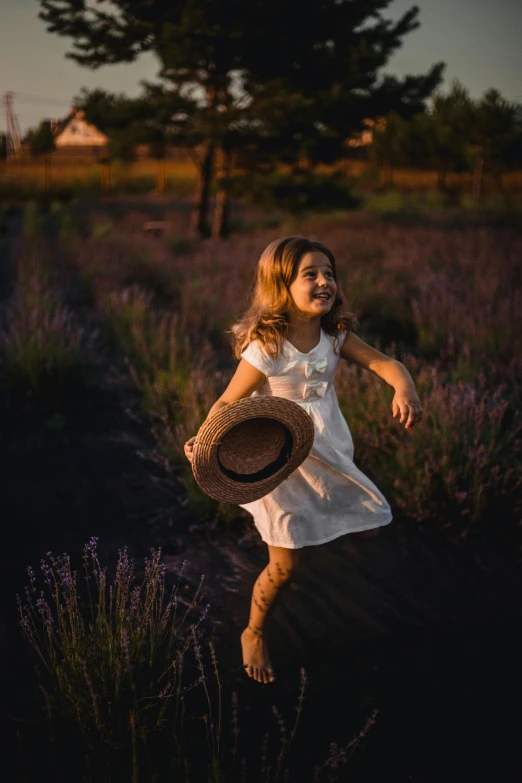 a little girl running through a field of lavender, by Andries Stock, pexels contest winner, soft evening lighting, she is wearing a hat, wearing a white sundress, 15081959 21121991 01012000 4k