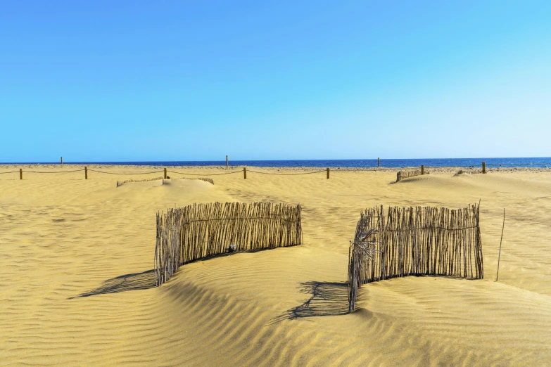 a wooden fence sitting on top of a sandy beach, by Andries Stock, pexels contest winner, land art, mexican desert, panoramic