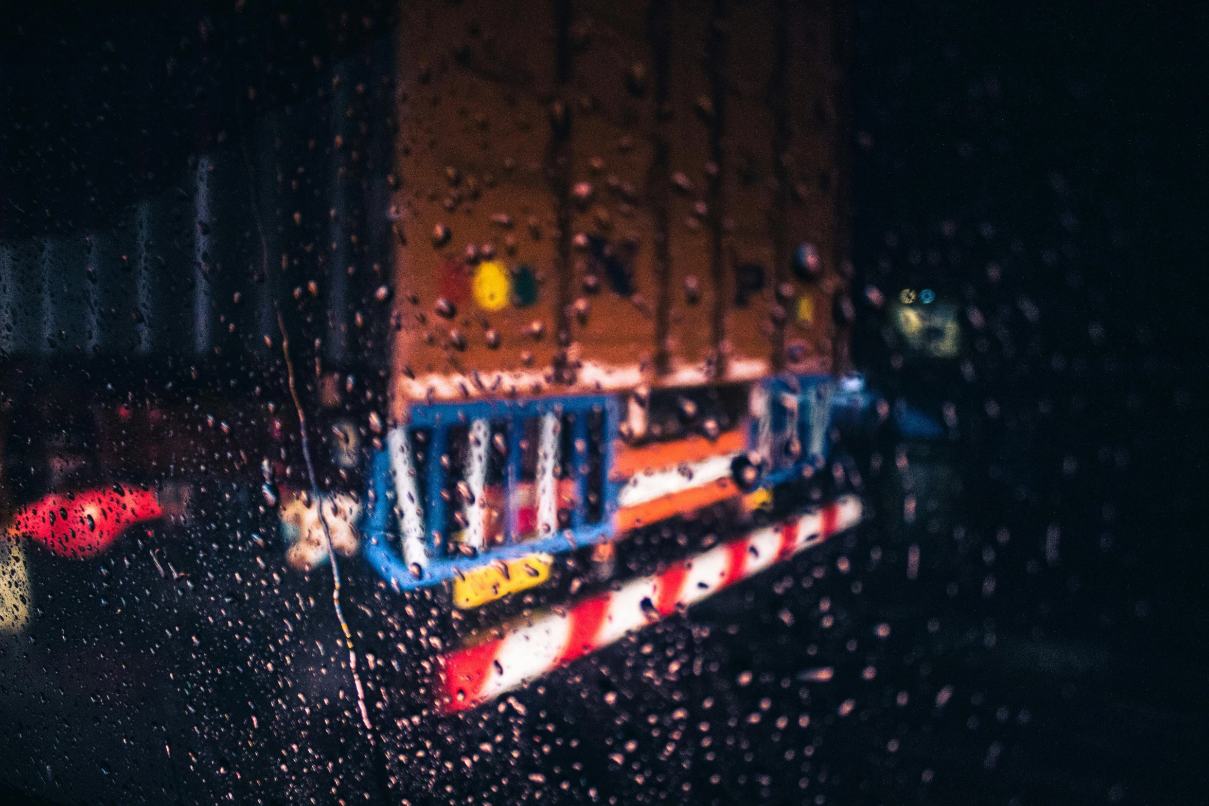 a view of a train through a rain covered window, inspired by Elsa Bleda, unsplash contest winner, photorealism, a firetruck at night, neon reflections, wet reflections in square eyes, unsplash 4k