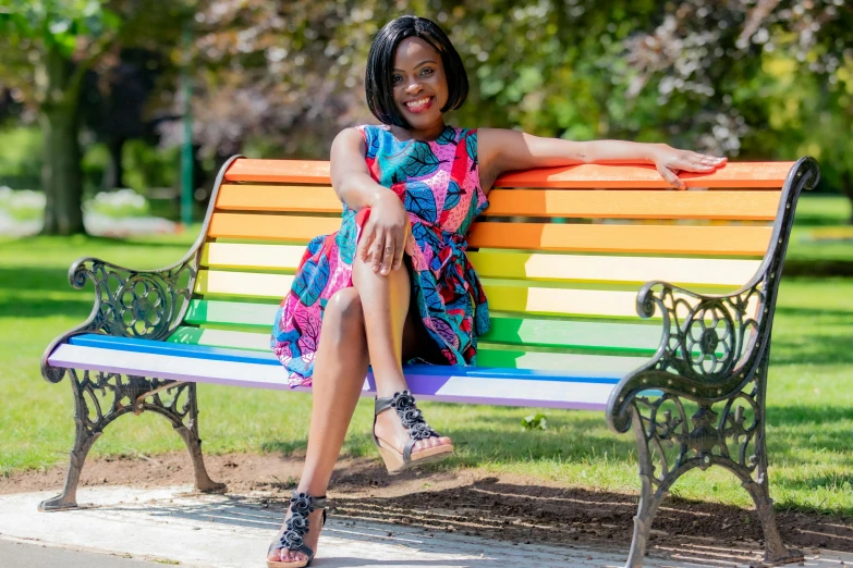 a woman sitting on a bench in a park, a portrait, inspired by Chinwe Chukwuogo-Roy, pexels, colorful outfit, avatar image, multicoloured, full shot photo