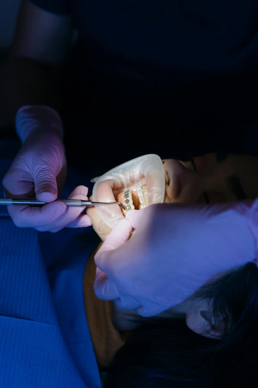 a close up of a person holding a pair of scissors, by Adam Marczyński, pexels contest winner, hyperrealism, glowing mouth, on an operating table, tooth, plating