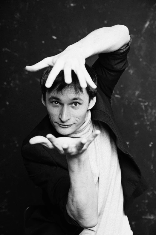 a black and white photo of a man with his hands on his head, an album cover, inspired by Dmitry Levitzky, elijah wood as harry potter, wave a hand at the camera, skinny male magician, taken in the mid 2000s