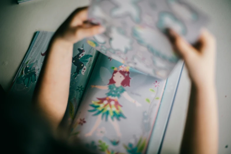 a close up of a person holding a book, a storybook illustration, process art, holographic creatures, ariel view, child's drawing, modelling