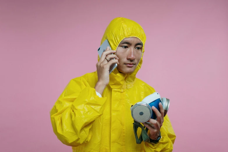 a man in a yellow rain suit talking on a cell phone, an album cover, by artist, pexels, yanjun chengt, dangerous chemical hazards, holding a very advance phone, it specialist