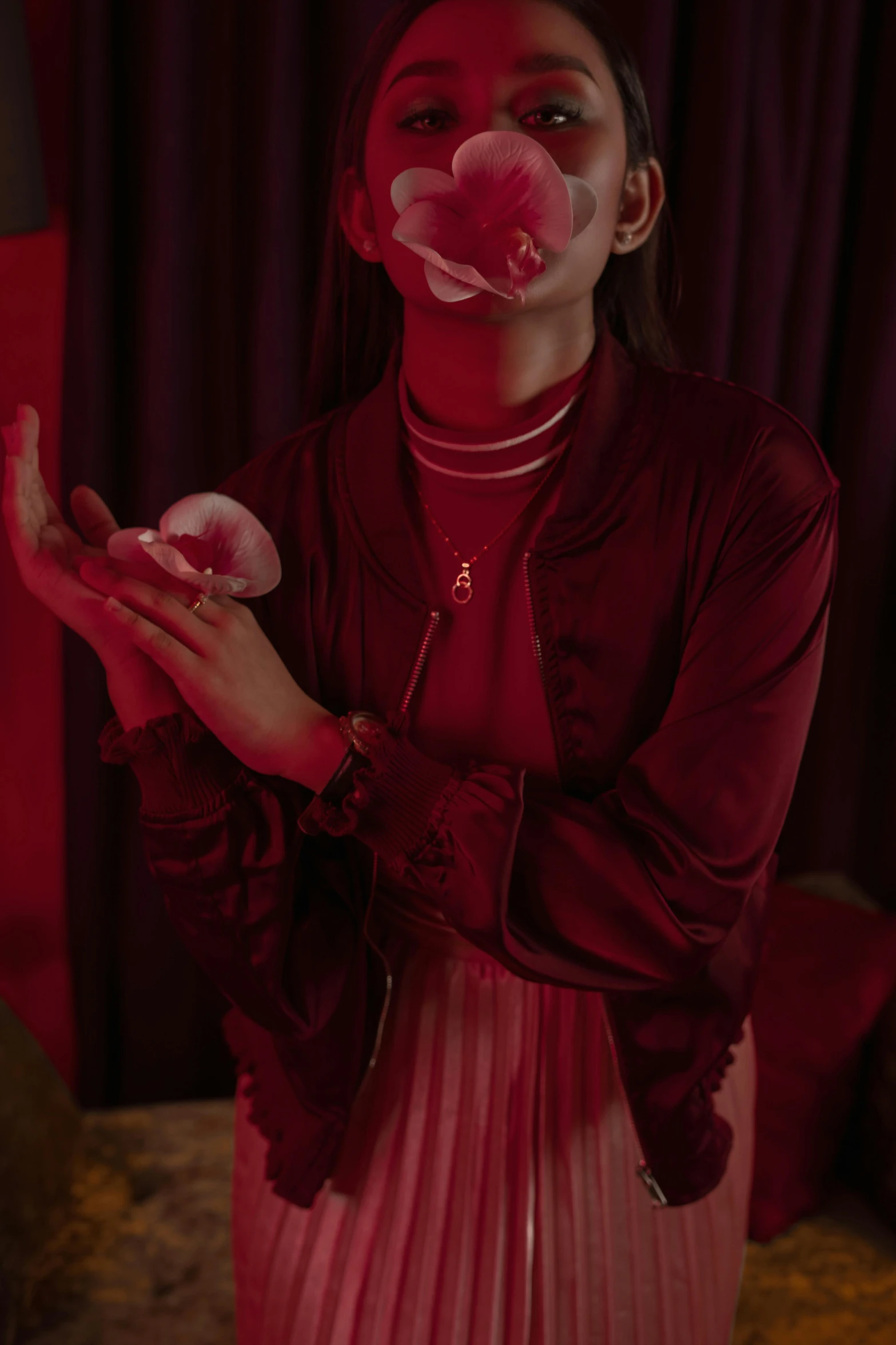 a woman blowing a bubble while standing in a room, an album cover, inspired by Elsa Bleda, trending on pexels, serial art, dressed in red velvet, asian girl, jewelry, blood on body