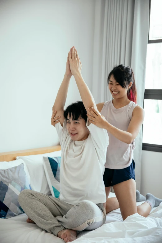 a couple of people sitting on top of a bed, inspired by Gong Kai, pexels contest winner, greeting hand on head, working out, teenage boy, wearing a shirt