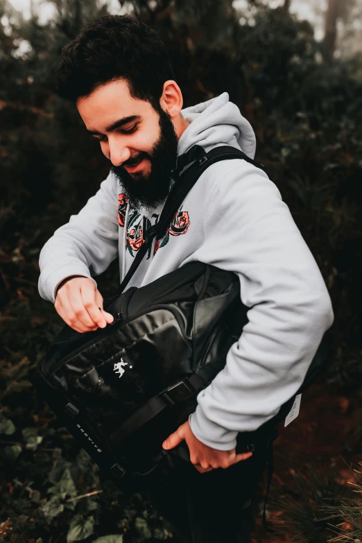 a man with a beard standing in the woods, featured on reddit, graffiti, carrying a saddle bag, official store photo, smiling down from above, /r/razer