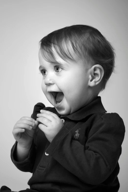 a black and white photo of a little boy, a black and white photo, pexels contest winner, pop art, <pointé pose>;open mouth, toddler, dressed in a suit, smiling amazed