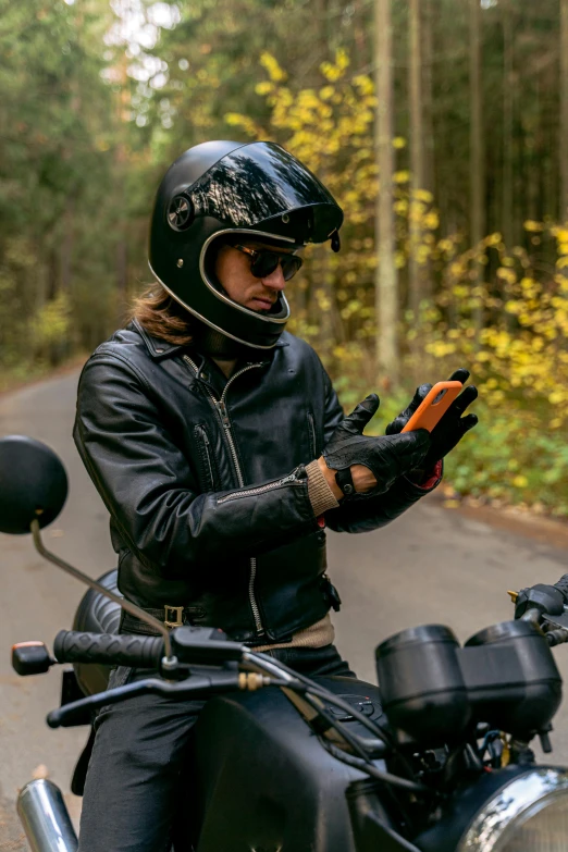 a person on a motorcycle with a cell phone, wearing gloves, profile image, rectangle, orange