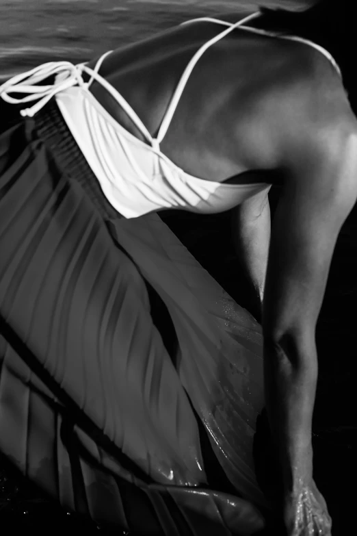 a black and white photo of a woman in a bikini, inspired by Lillian Bassman, pleated skirt, detail, african american woman, in style of caravaggio