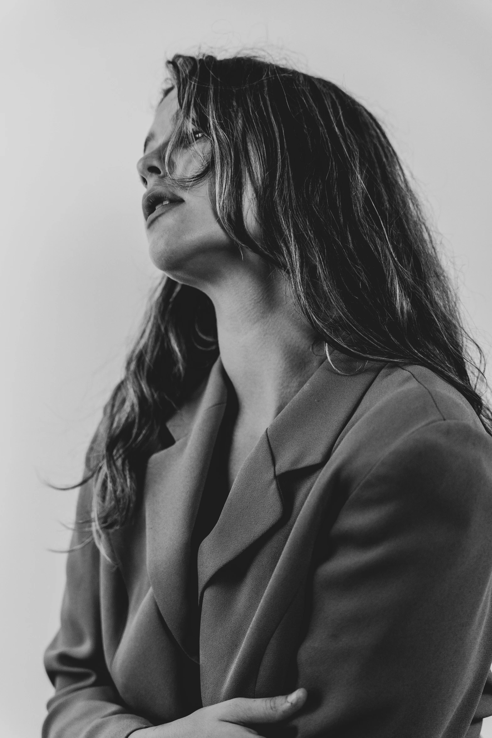 a black and white photo of a woman with long hair, a black and white photo, by Emma Andijewska, trending on pexels, wearing a worn out suit, profile pose, max dennison, girl with brown hair