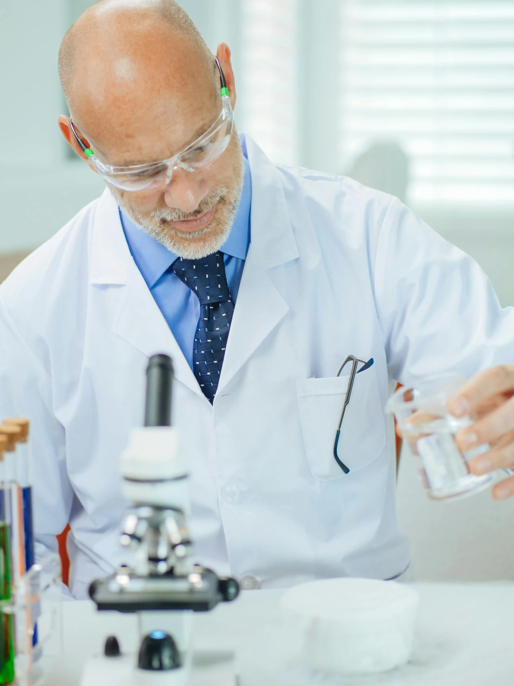 a man in a lab coat is pouring something into a glass, school curriculum expert, lgbtq, thumbnail, surgery