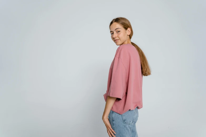 a woman wearing a pink top and jeans, by Attila Meszlenyi, trending on unsplash, on grey background, curled slightly at the ends, short sleeves, lofi girl