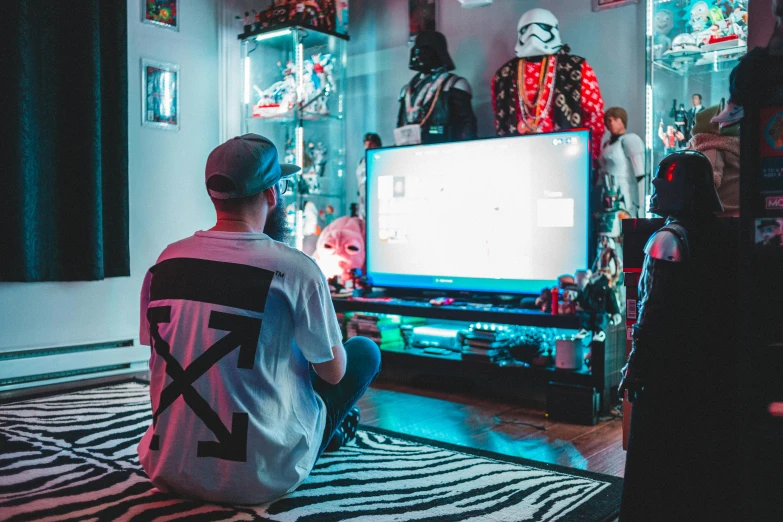 a man sitting on the floor in front of a television, cyberpunk art, pexels contest winner, maximalism, twins playing video games, outlive streetwear collection, star wars themed, long shot from the back