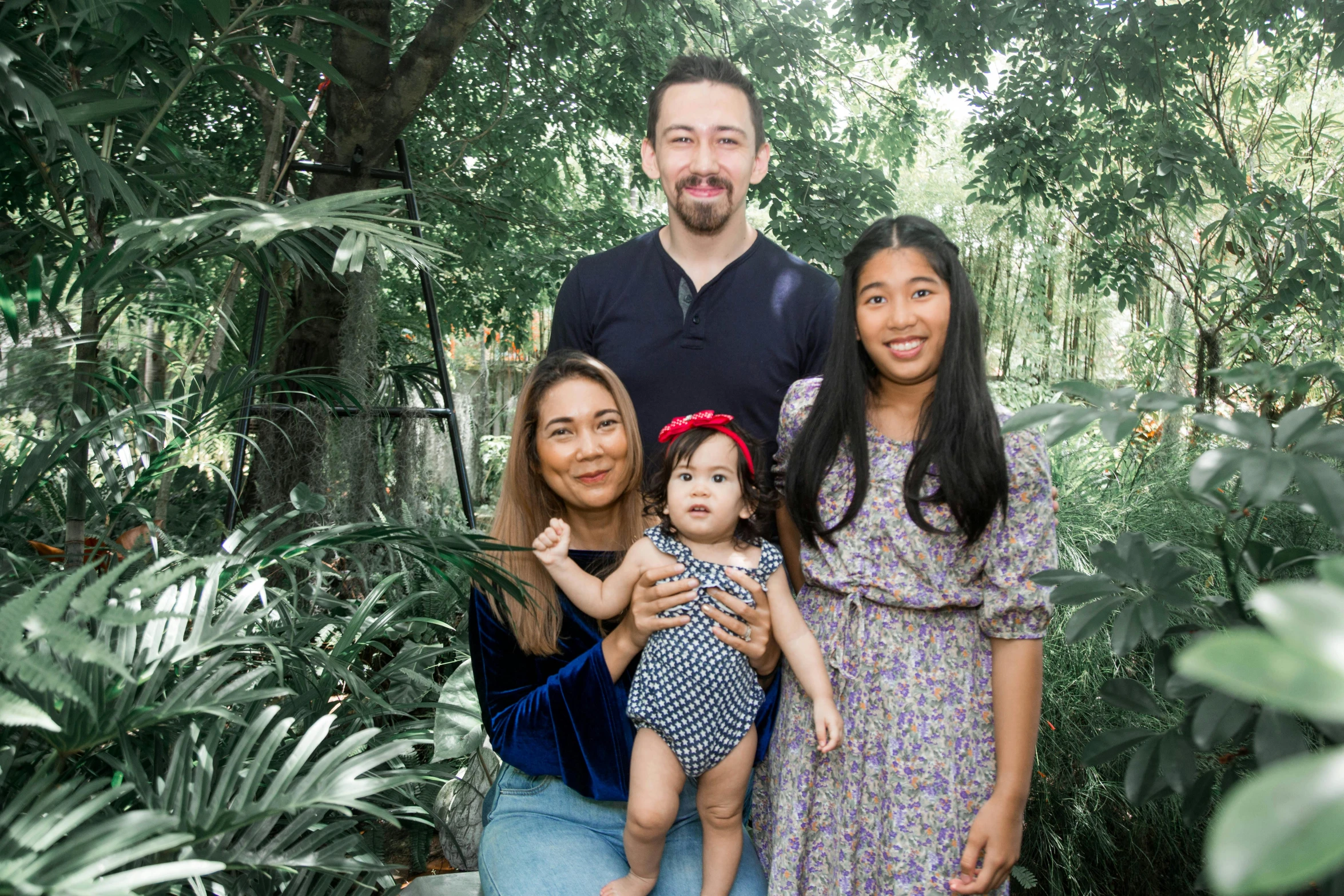 a family poses for a picture in the woods, a portrait, inspired by Ruth Jên, standing in a botanical garden, avatar image