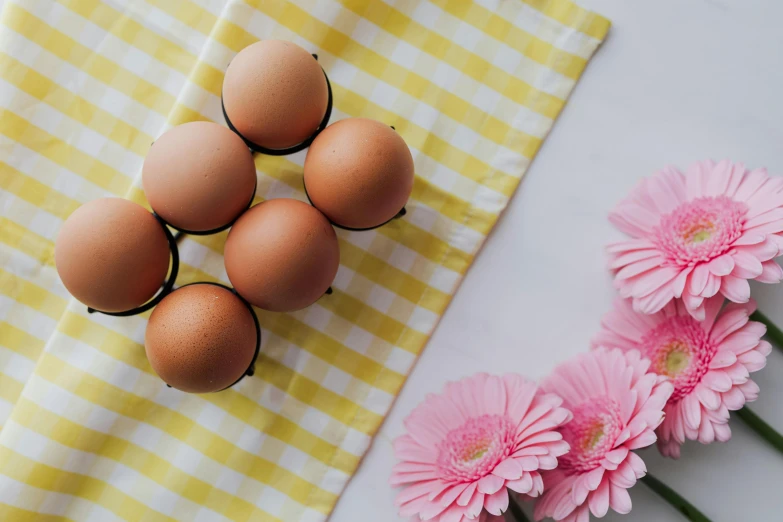 a bunch of eggs sitting on top of a table next to pink flowers, pexels contest winner, polka dot, on a yellow canva, slightly tanned, perfectly tileable