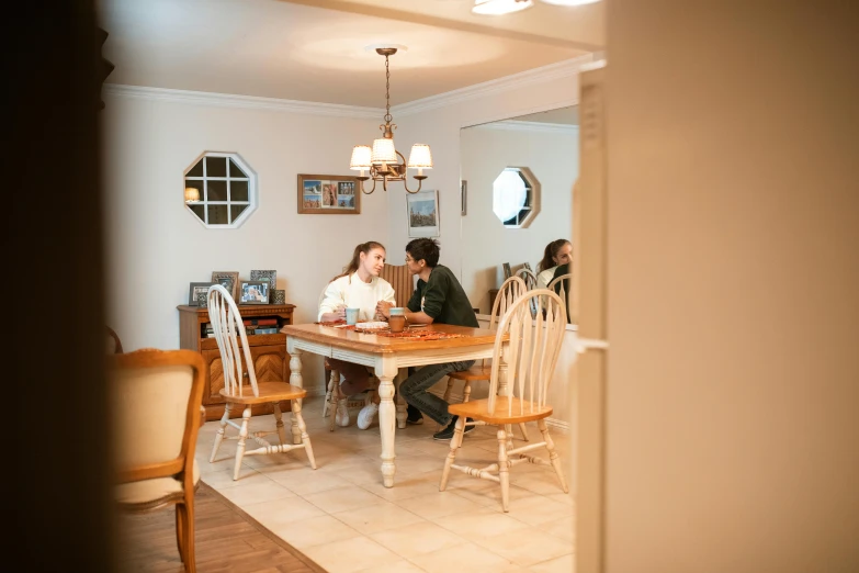 a couple of people that are sitting at a table, by Carey Morris, unsplash, renaissance, residential, house interior, brown, lynn skordal