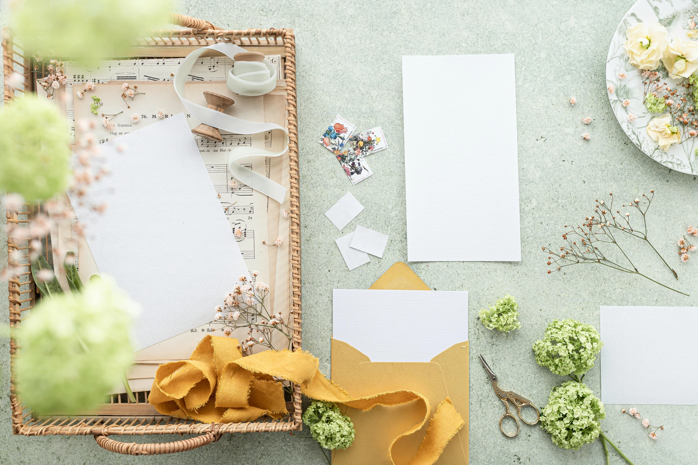 a basket filled with flowers sitting on top of a table, inspired by Eden Box, pexels contest winner, private press, parchment paper, white and gold color palette, writing a letter, set pieces