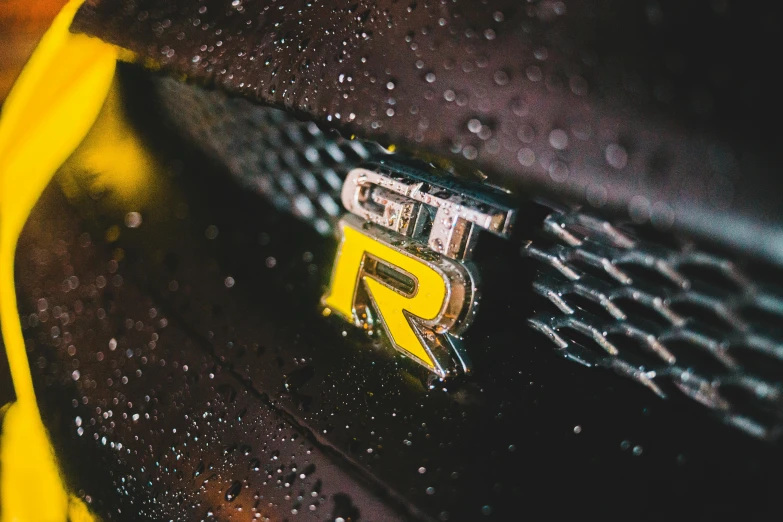 a close up of a yellow and black sports car, a picture, by Greg Rutkowski, trending on unsplash, photorealism, rainy wet, gtr xu1, close up shot of an amulet, header with logo