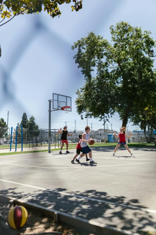 a group of people playing a game of basketball, los angelos, well shaded, let's play, local gym