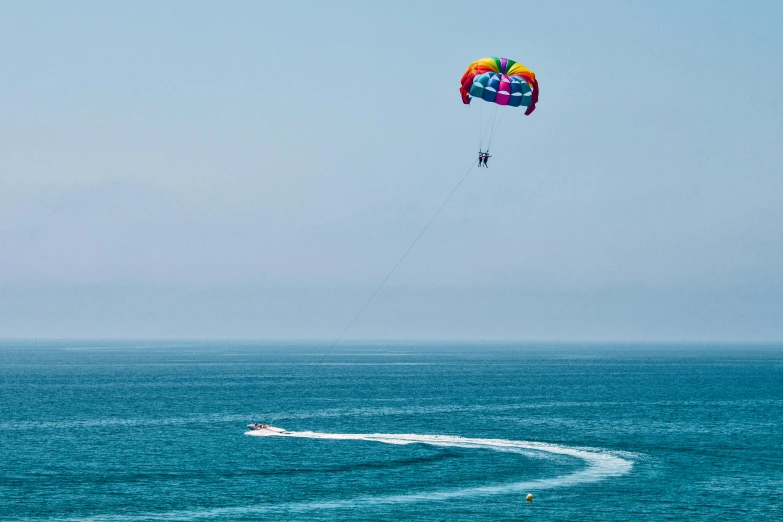 a person parasailing over a body of water, by Liza Donnelly, pexels contest winner, hollister ranch, multi colour, ocean view, thumbnail