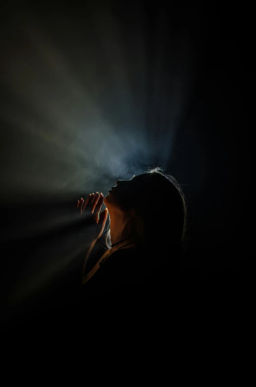 a woman singing into a microphone in the dark, an album cover, by Adam Chmielowski, pexels contest winner, light and space, holy light rays, woman crying, refracted light, doing a prayer