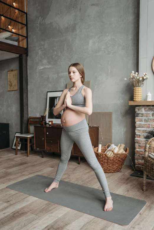 a pregnant woman standing on a yoga mat in a living room, a picture, pexels contest winner, dynamic active running pose, grey, anna nikonova aka newmilky, leggings