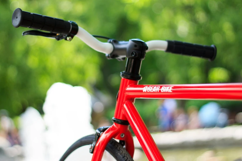 a red bike parked in front of a fountain, profile image, from yowamushi pedal, upper body close up, against the backdrop of trees