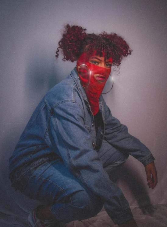 a woman with red paint on her face, an album cover, inspired by Elsa Bleda, pexels, afrofuturism, sitting down casually, red hood cosplay, red curly hair, ( ( dark skin ) )