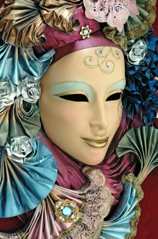 a close up of a mask with flowers on it, an album cover, inspired by Andrea del Verrocchio, pexels contest winner, court jester in renaissance era, color image, pareidolia, diverse costumes