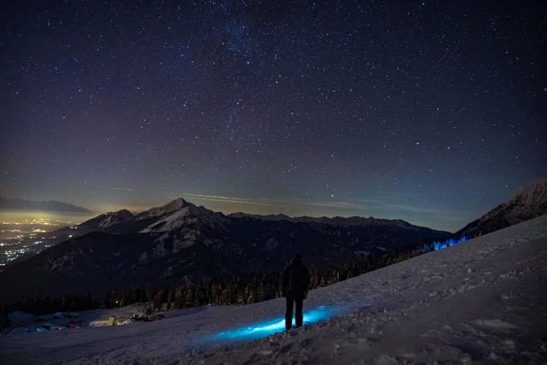 a person standing on top of a snow covered slope, by Sebastian Spreng, pexels contest winner, glowing stars, wide view, outdoor photo, today\'s featured photograph 4k